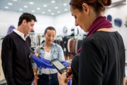 retail worker with handheld computer with customers